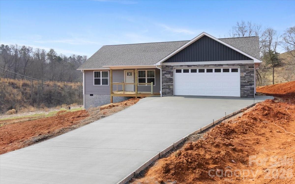 94 Baileys Cove Road, Unit 9 Marshall, NC 28753 - Photo 2 of 30 a front view of a house with a yard and garage