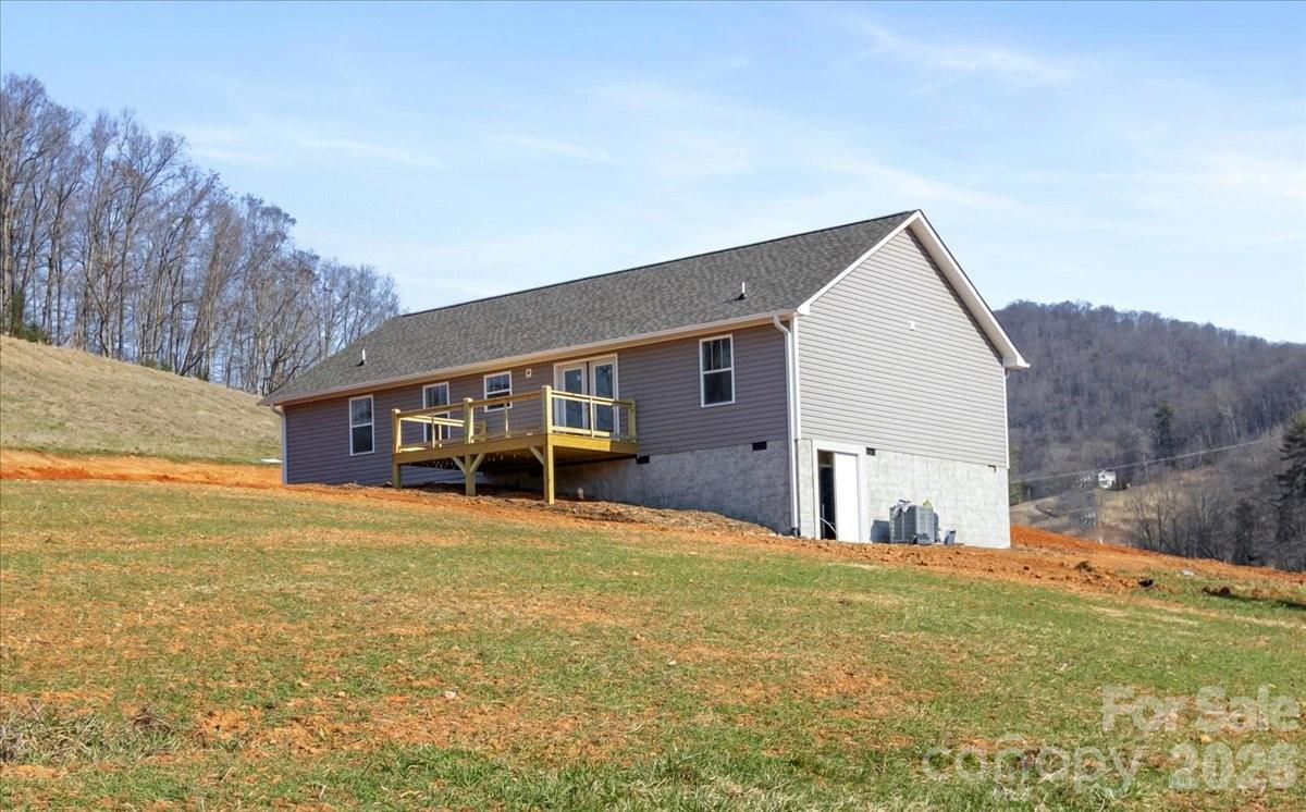 94 Baileys Cove Road, Unit 9 Marshall, NC 28753 - Photo 4 of 30 a view of a house with a yard and garage