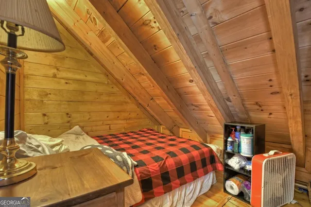 a bedroom with a bed a flat screen tv and windows