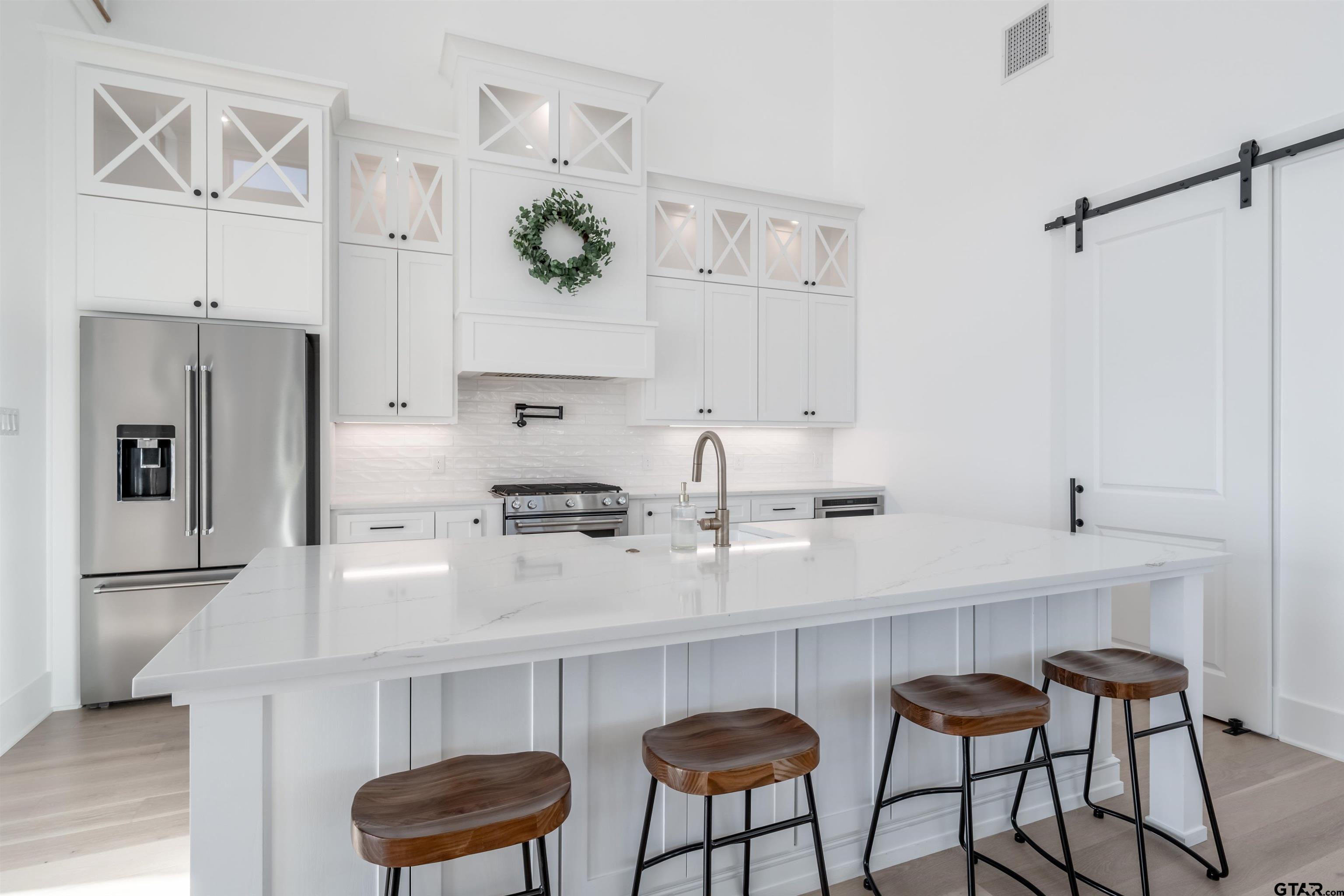 3005 Forest Trail Tyler, TX 75703 - Photo 4 of 32 a kitchen with stainless steel appliances a table and chairs in it