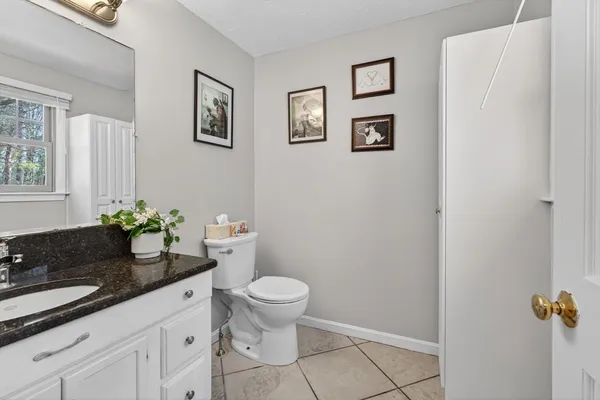 a bathroom with a granite countertop toilet and sink
