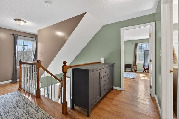 a view of hallway with wooden floor and stairs