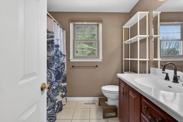 a bathroom with a sink toilet and window
