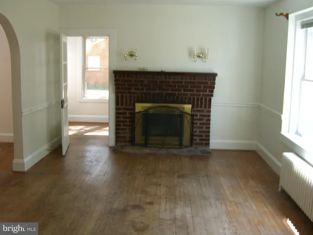 an empty room with windows and fireplace