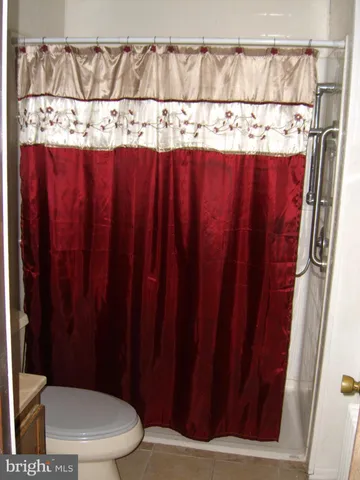 a bathroom with a toilet and a shower curtain