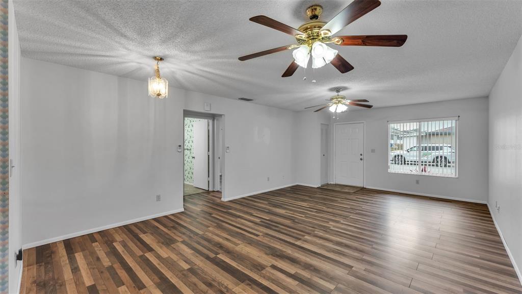 381 Winter Ridge Boulevard Winter Haven, FL 33881 - Photo 20 of 50 a view of an empty room with chandelier fan and wooden floor
