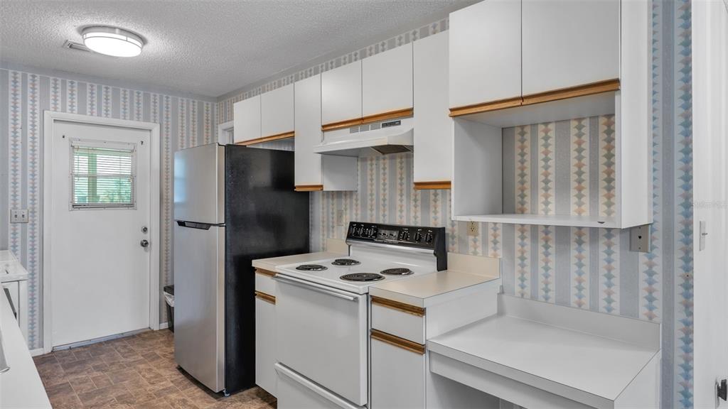 381 Winter Ridge Boulevard Winter Haven, FL 33881 - Photo 6 of 50 a kitchen with a refrigerator and a stove top oven