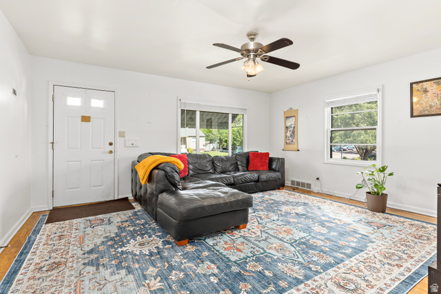 372 800 East Provo, UT 84606 - Photo 3 of 29 Bright living area featuring white walls, wood-finish flooring, a ceiling fan with integrated lighting, and multiple windows