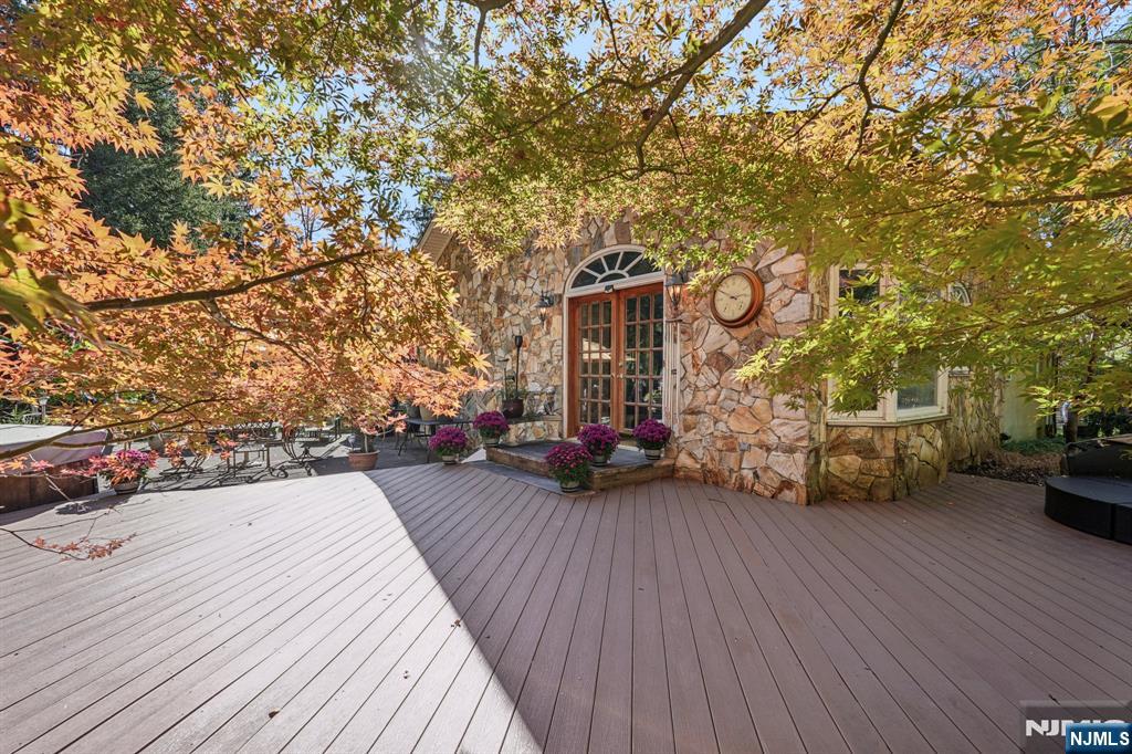 59 Old Stone Church Road Upper Saddle River, NJ 07458 - Photo 18 of 24 a view of a patio with table and chairs with wooden floor and fence