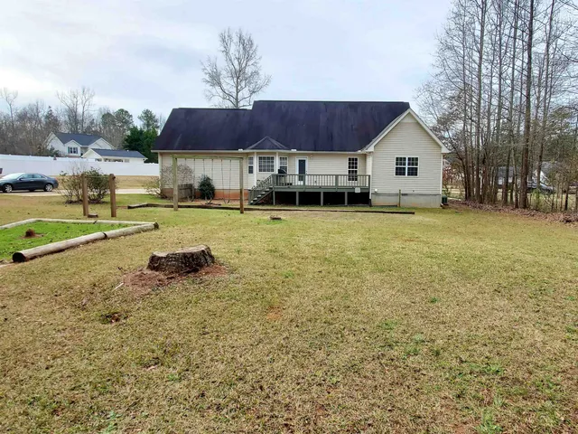 a front view of a house with a yard and trees
