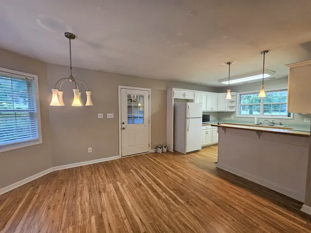 a view of a kitchen with a stove wooden cabinets and a window