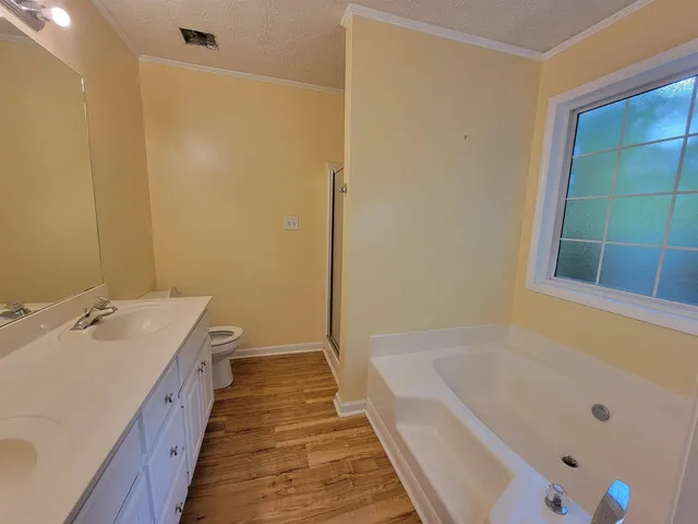 a spacious bathroom with a tub sink and mirror