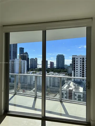 a room with open cabinet and glass door