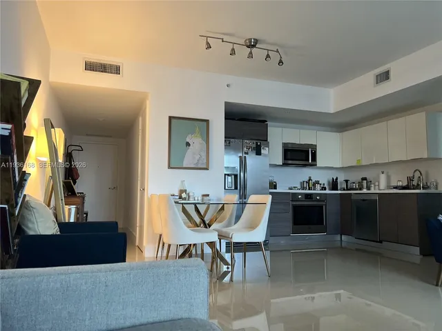 a living room with stainless steel appliances kitchen island granite countertop furniture and a kitchen view