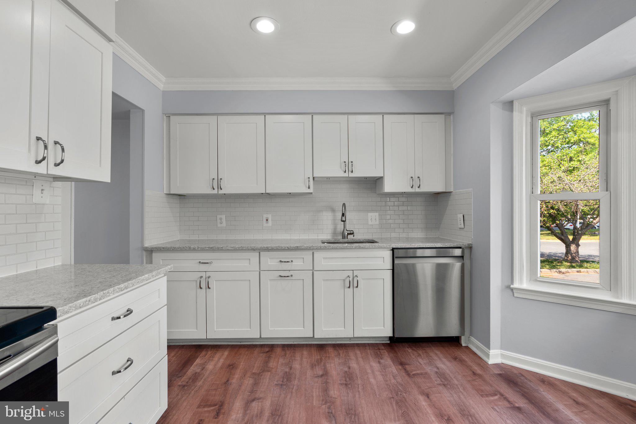 9130 Bobwhite Circle Gaithersburg, MD 20879 - Photo 11 of 36 a kitchen with granite countertop white cabinets and wooden floor