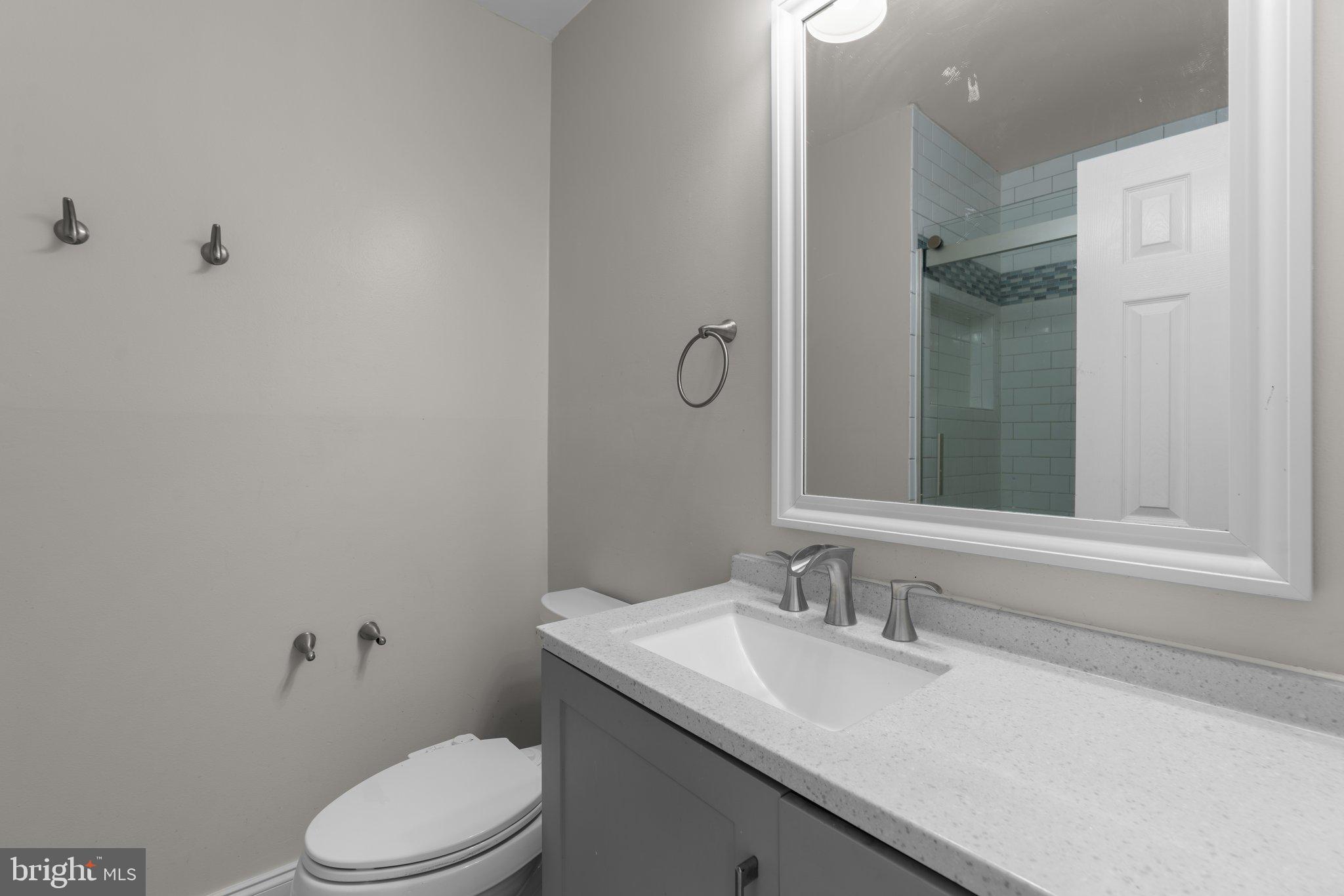 9130 Bobwhite Circle Gaithersburg, MD 20879 - Photo 19 of 36 a bathroom with a granite countertop sink a toilet and a mirror
