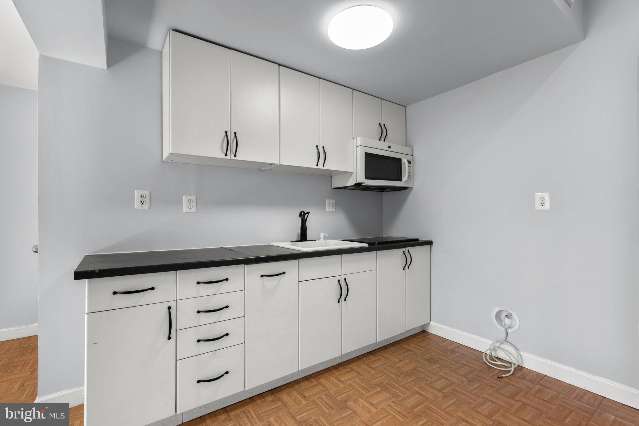 9130 Bobwhite Circle Gaithersburg, MD 20879 - Photo 26 of 36 a kitchen with granite countertop white cabinets and sink
