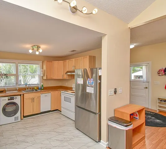 a kitchen with stainless steel appliances granite countertop a refrigerator and a stove top oven