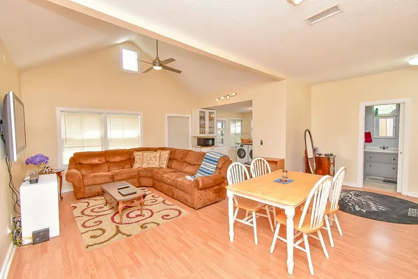 a living room with furniture a chandelier and a flat screen tv