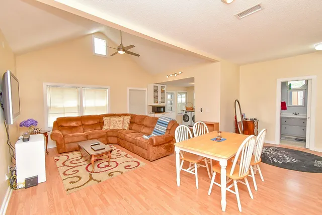 a living room with furniture a chandelier and a flat screen tv