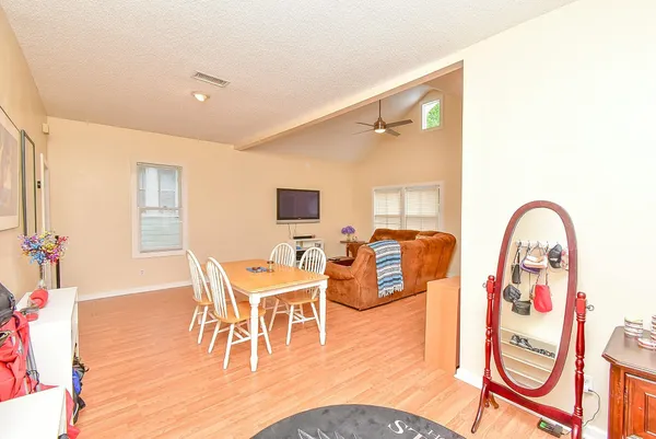 a dining room with furniture a chandelier and wooden floor
