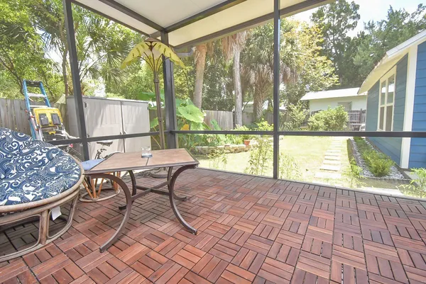 a view of a patio with table and chairs and wooden floor