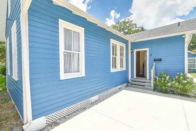 a view of a house with backyard and tree