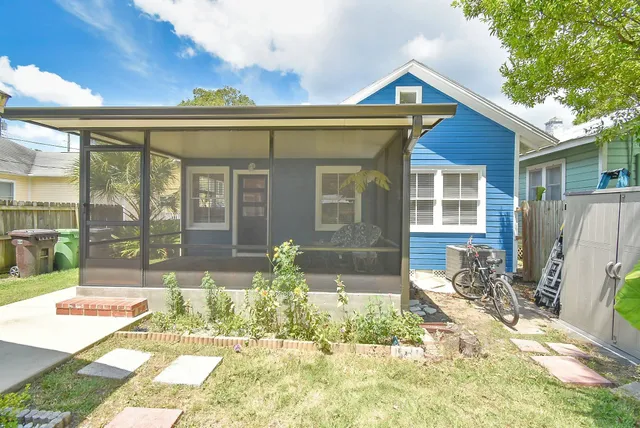 a backyard of a house with potted plants and wooden fence