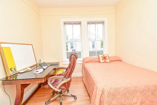 a bed sitting in a bedroom next to a window