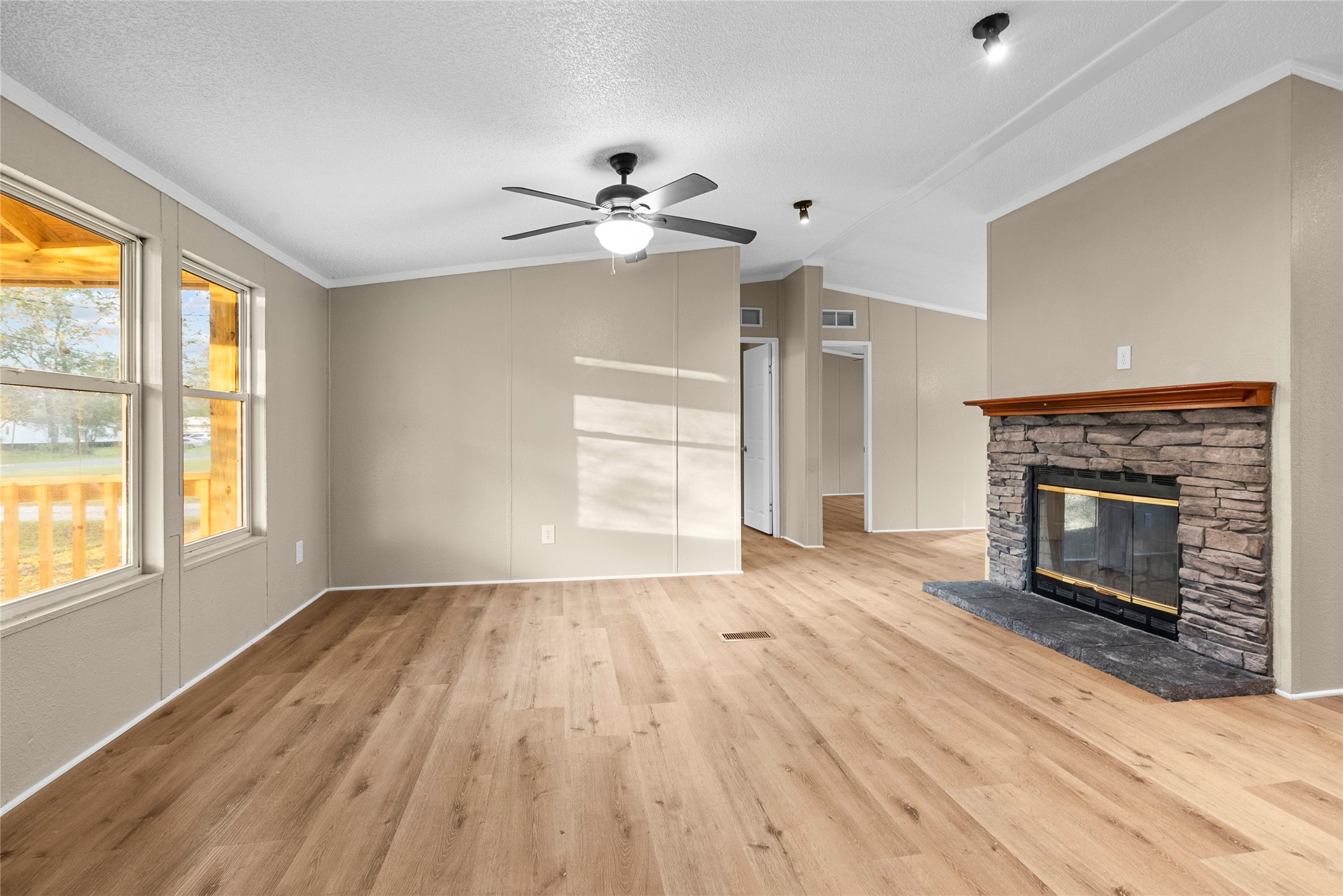 12902 Indian Ridge Drive Dayton, TX 77535 - Photo 9 of 31 an empty room with windows fireplace and wooden floor