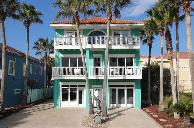 a front view of a building with glass windows and a tree