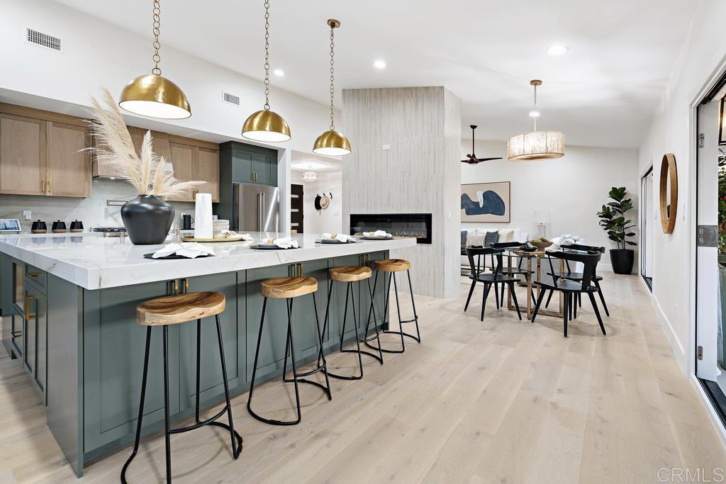 14224 Recuerdo Drive Del Mar, CA 92014 - Photo 2 of 21 a kitchen with stainless steel appliances granite countertop a stove a sink dishwasher a dining table and chairs with wooden floor