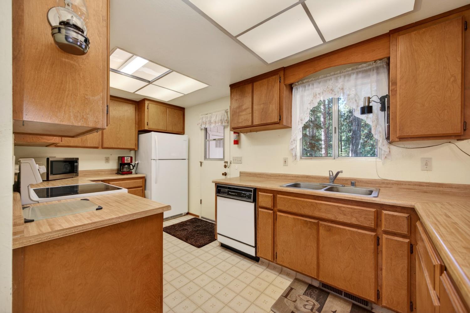 20191 Kit Court Volcano, CA 95689 - Photo 25 of 54 a kitchen with stainless steel appliances a refrigerator sink and wooden cabinets