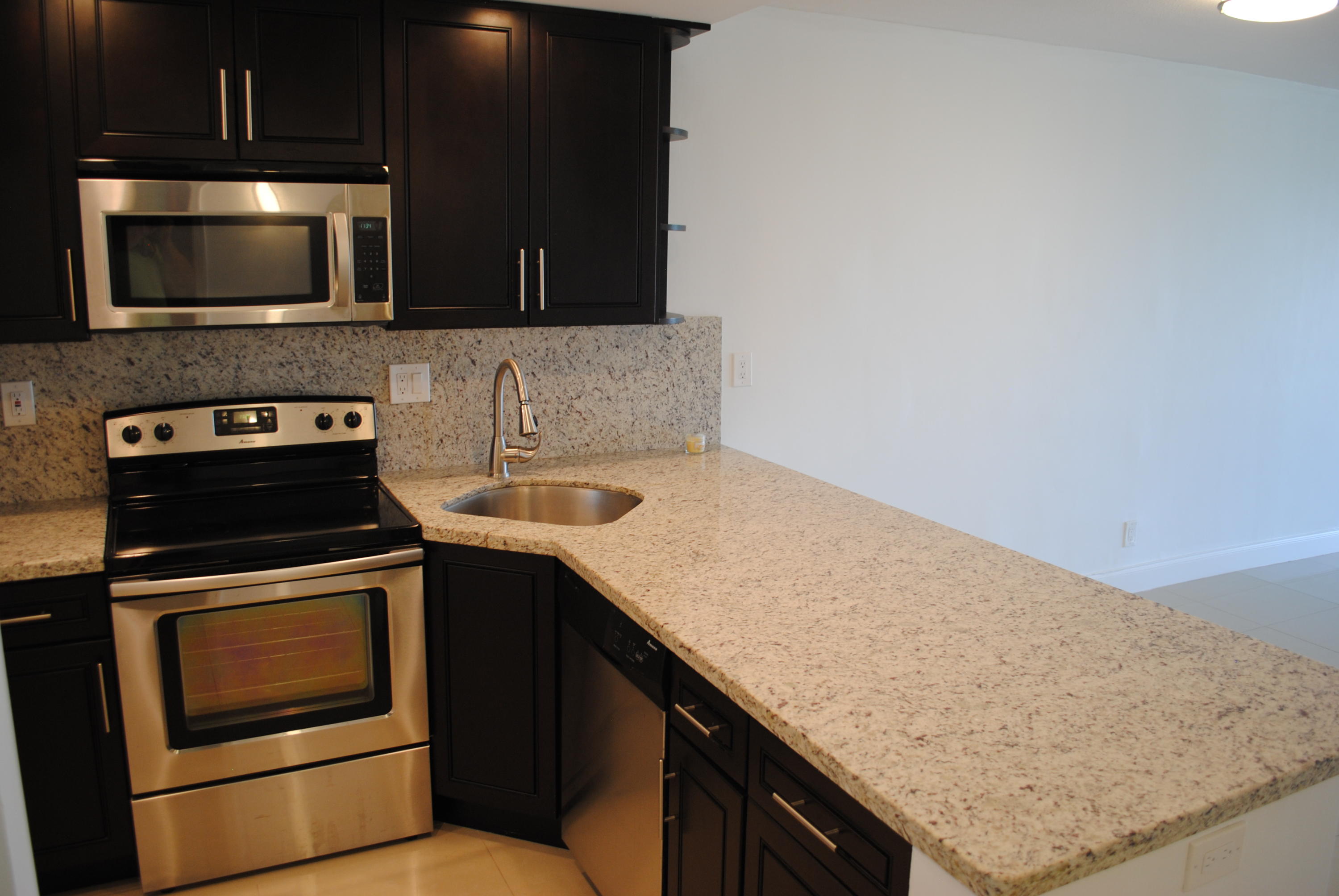 750 Northeast Spanish River Boulevard, Unit 503 Boca Raton, FL 33431 - Photo 2 of 32 a kitchen with a stove and a microwave