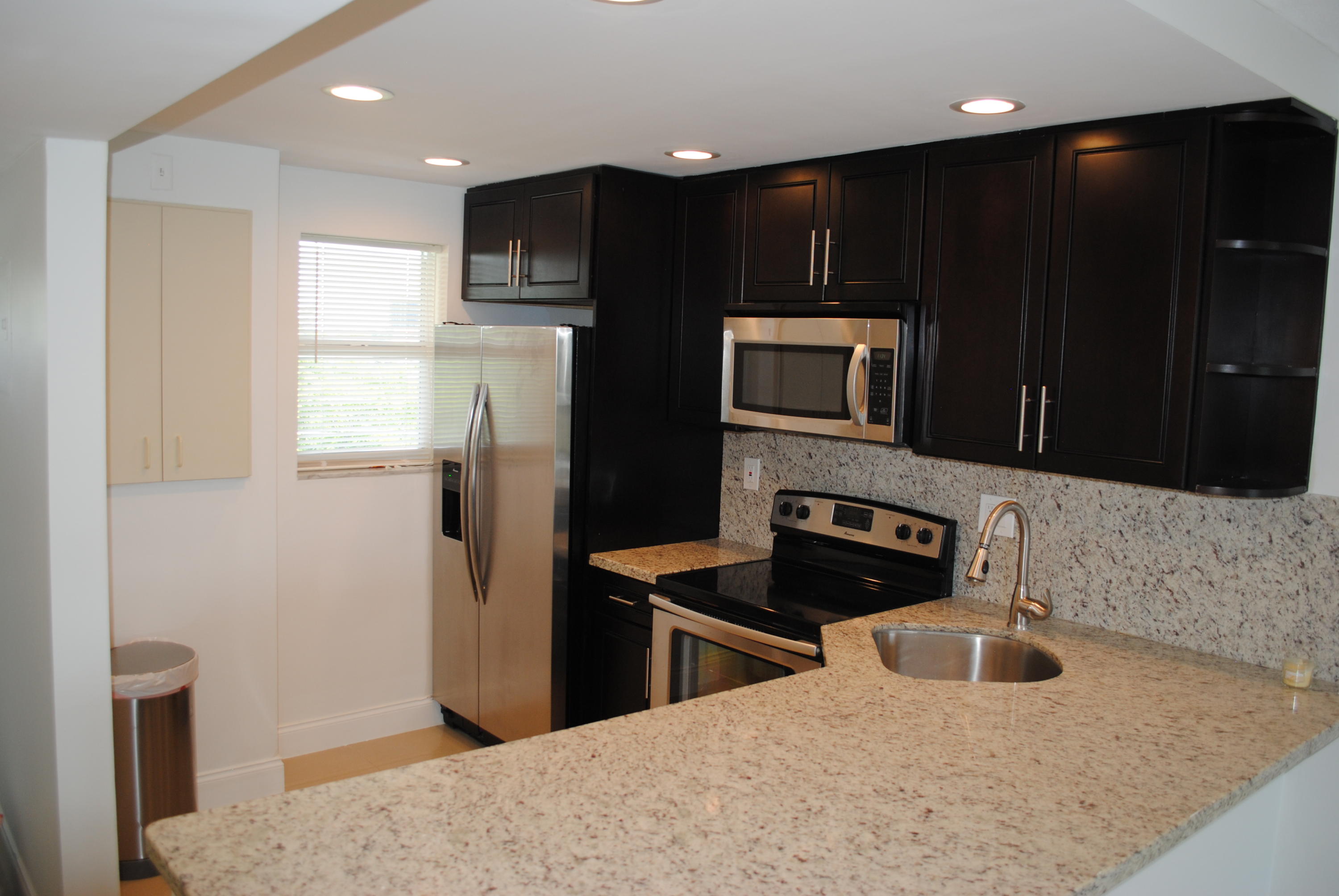 750 Northeast Spanish River Boulevard, Unit 503 Boca Raton, FL 33431 - Photo 3 of 32 a kitchen with granite countertop a refrigerator stove and sink