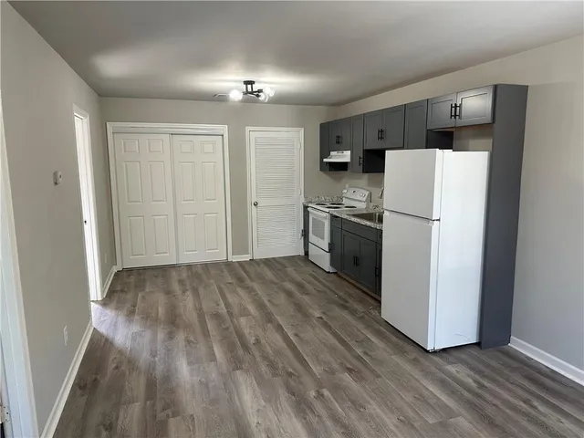 a view of a kitchen with wooden floor and electronic appliances