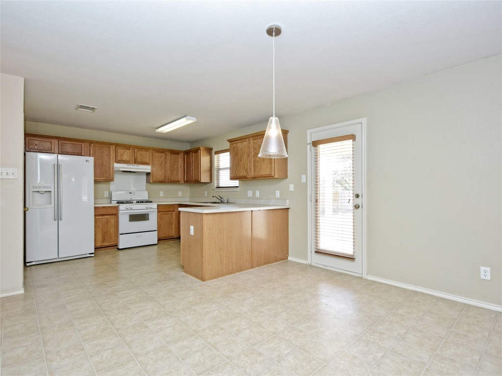 3600 Spring Canyon Trail Round Rock, TX 78681 - Photo 29 of 30 a kitchen with stainless steel appliances granite countertop a sink a stove a refrigerator a white cabinets and window