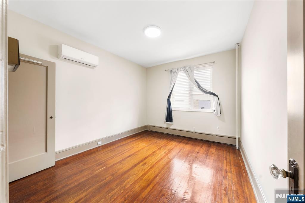 598 67th Street, Unit 1 West New York, NJ 07093 - Photo 15 of 22 an empty room with wooden floor and windows