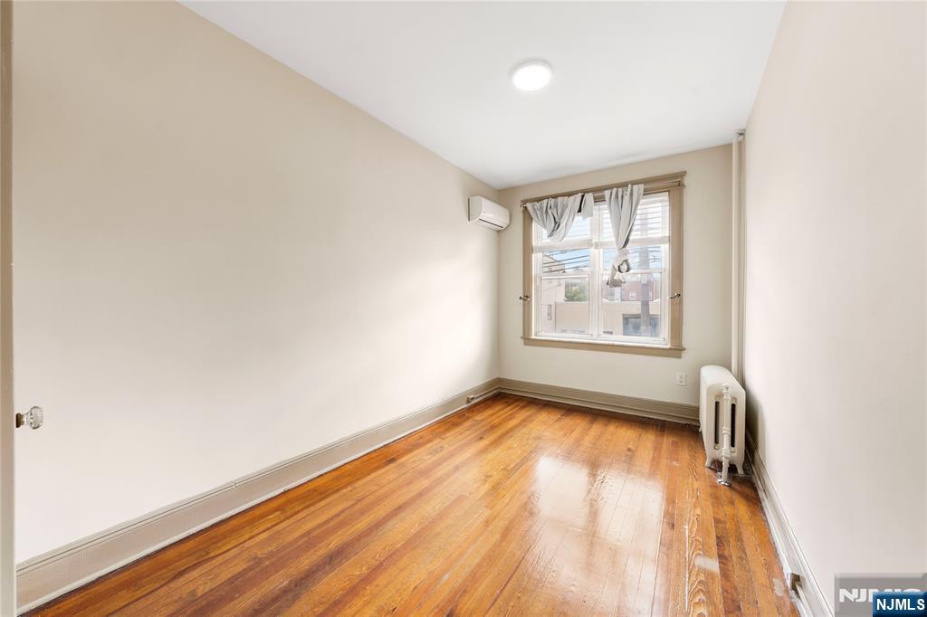 598 67th Street, Unit 1 West New York, NJ 07093 - Photo 8 of 22 an empty room with wooden floor and windows