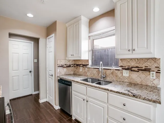 a kitchen with granite countertop a sink and cabinets