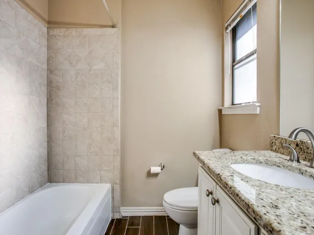 a bathroom with a granite countertop sink toilet and shower