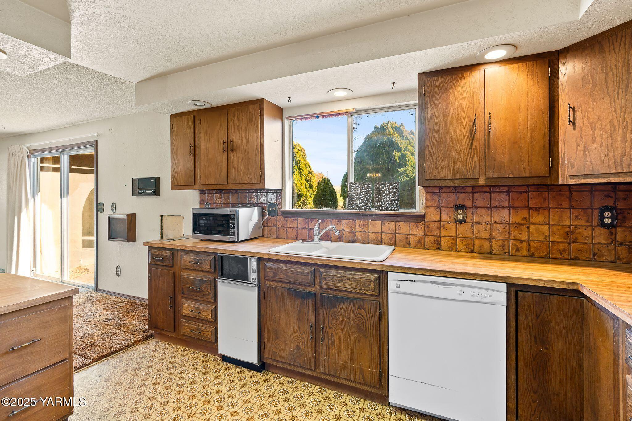 151 Morrow Road Moxee, WA 98936 - Photo 12 of 34 a kitchen with a sink window and cabinets