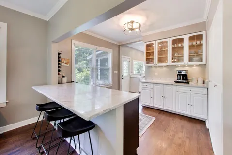 a kitchen with stainless steel appliances kitchen island a large window and cabinets