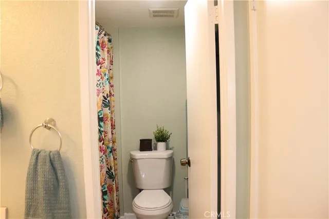 a white toilet sitting next to a shower curtain