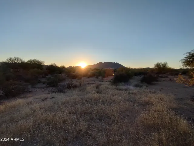 a view of a dry yard with mountains in the background