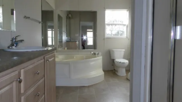 a bathroom with a toilet a sink and mirror