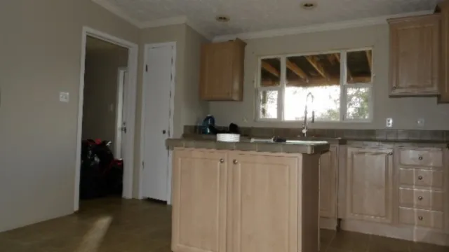 a kitchen with granite countertop a sink and a stove top oven