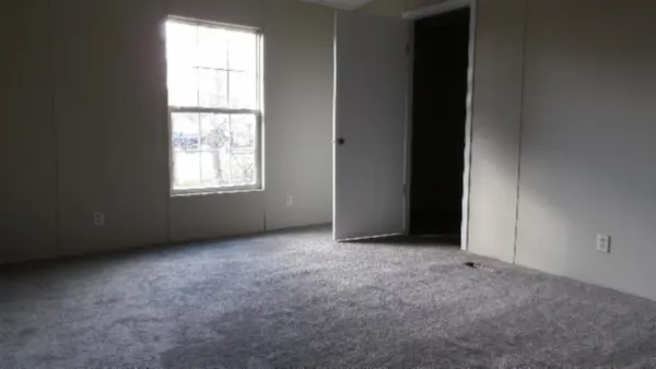 an empty room with windows and closet