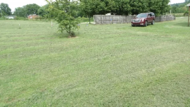 a car parked in front of a house with yard