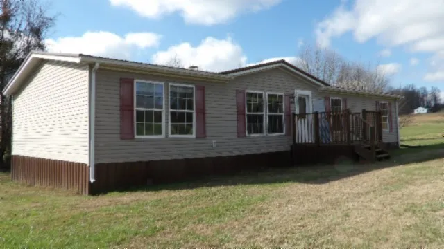 a view of house with backyard and glass windows